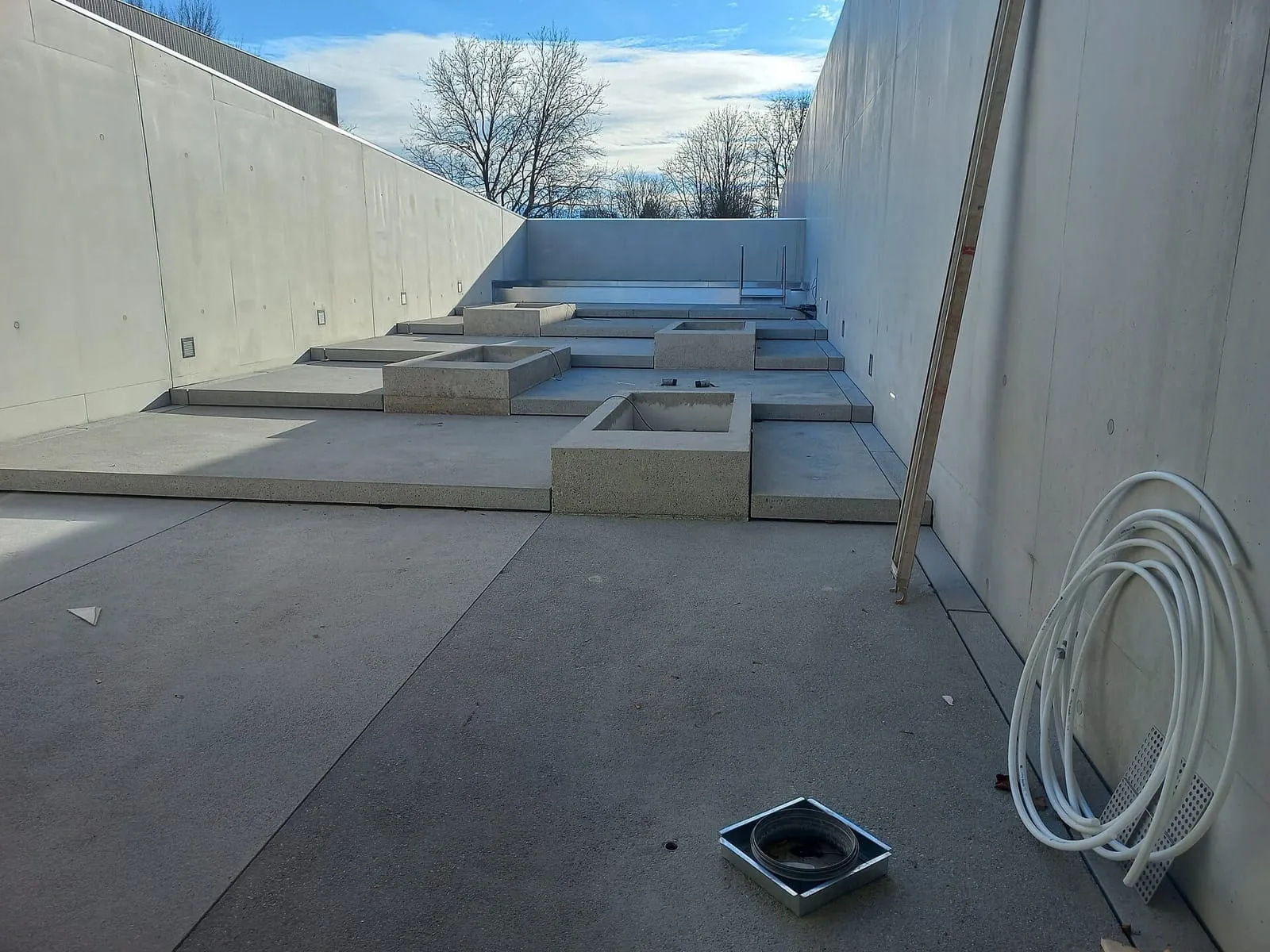 Tinas de concreto de una zona húmeda en construcción, al aire libre, entre muros de concreto en el Seebad de Bregenz