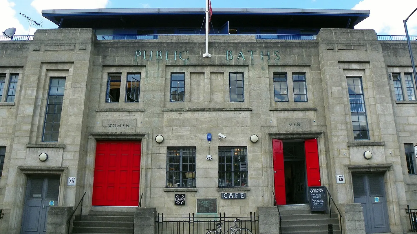 Fachada art déco de los antiguos baños públicos de Eastway, en Hackney Wick, con las puertas rojas marcadas Women y Men