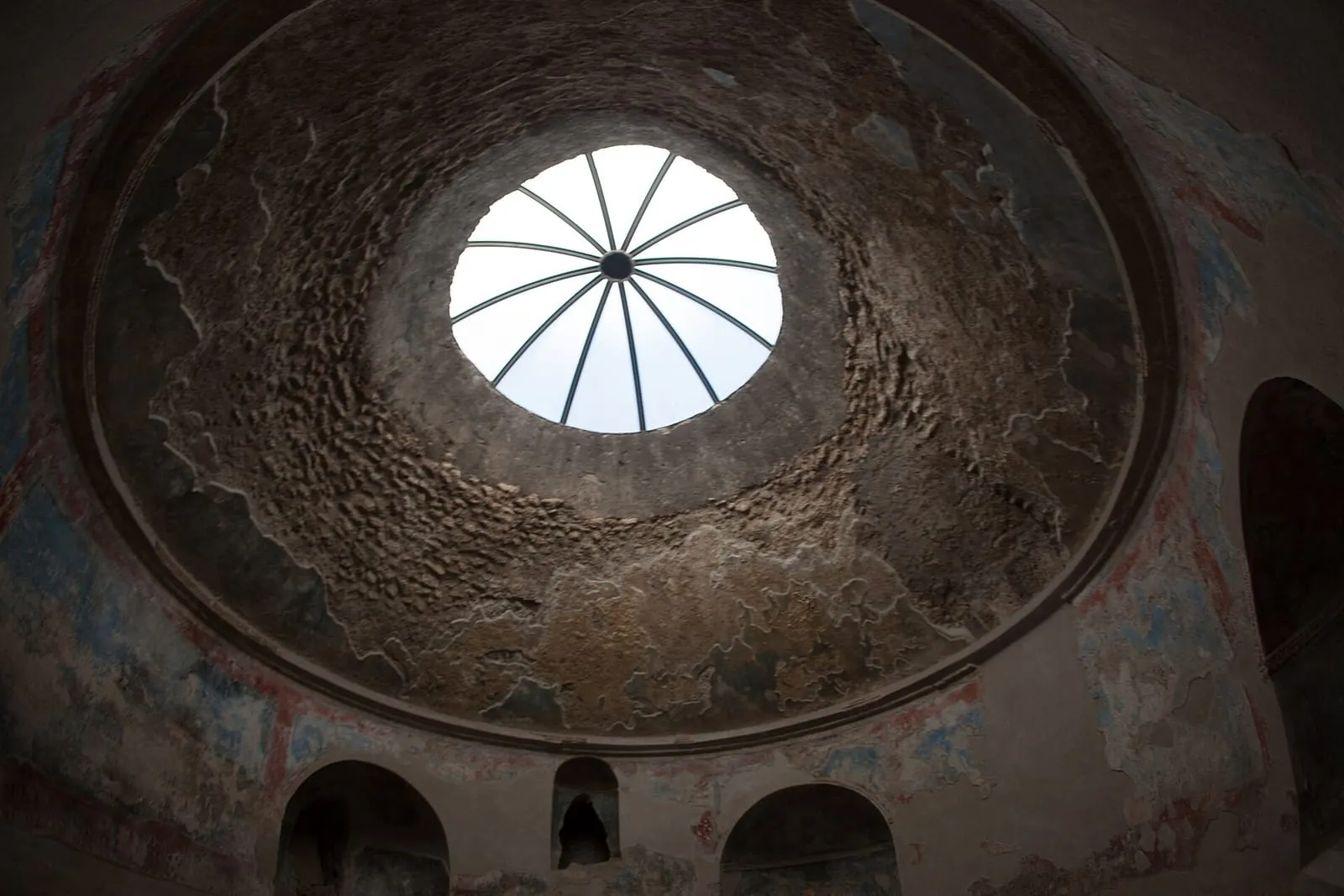 Sala abovedada de las Termas Estabianas, en Pompeya, con óculo en el techo, nichos en las paredes y restos de estuco pintado