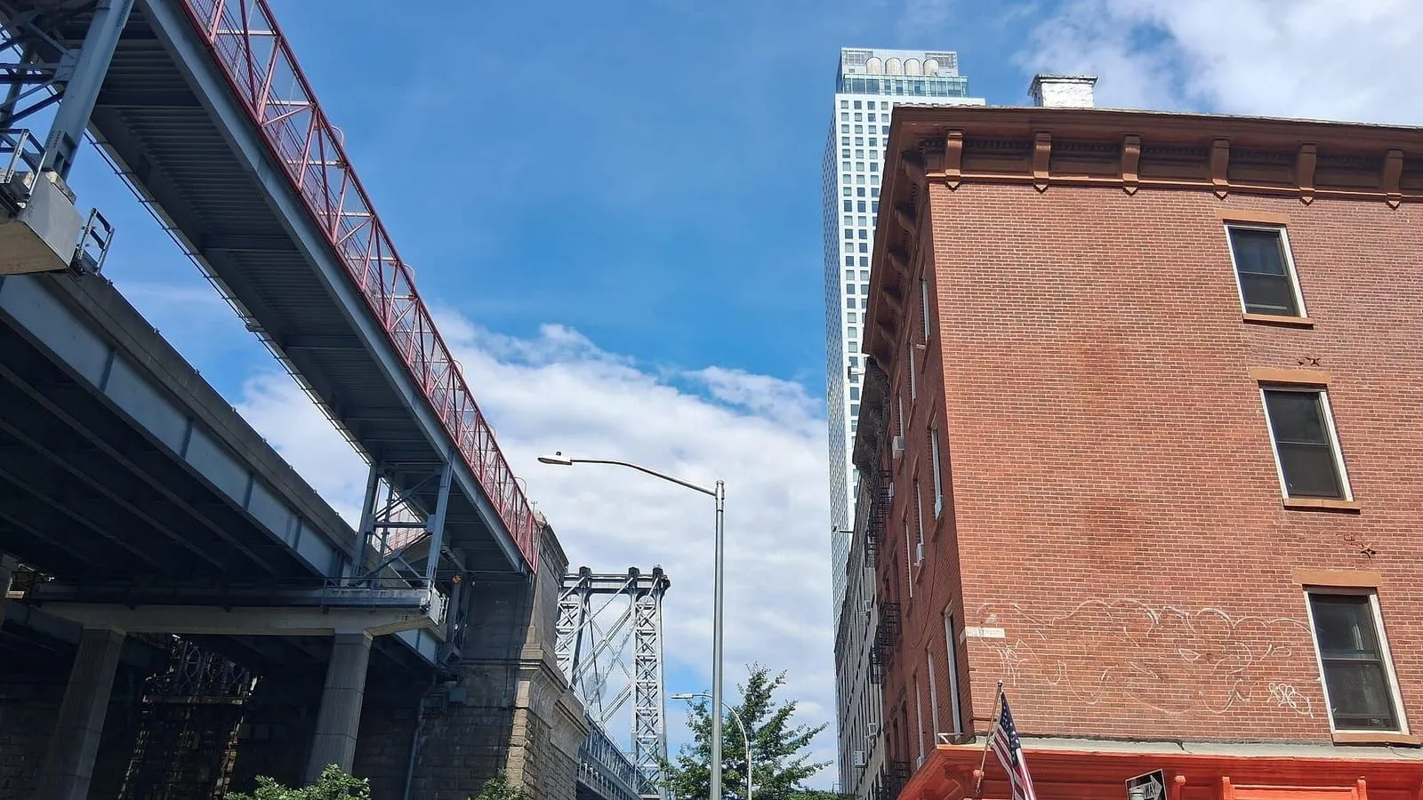 Calle de Williamsburg, en Brooklyn, con el puente de Williamsburg al fondo y edificios de ladrillo